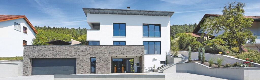 Hanghaus richtig bauen 3 Modernes Hanghaus bauen mit weißer Fassade und Klinkerdekor an der Garage